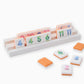 Oh My Mahjong Orange Rummi tile set on white wooden racks
