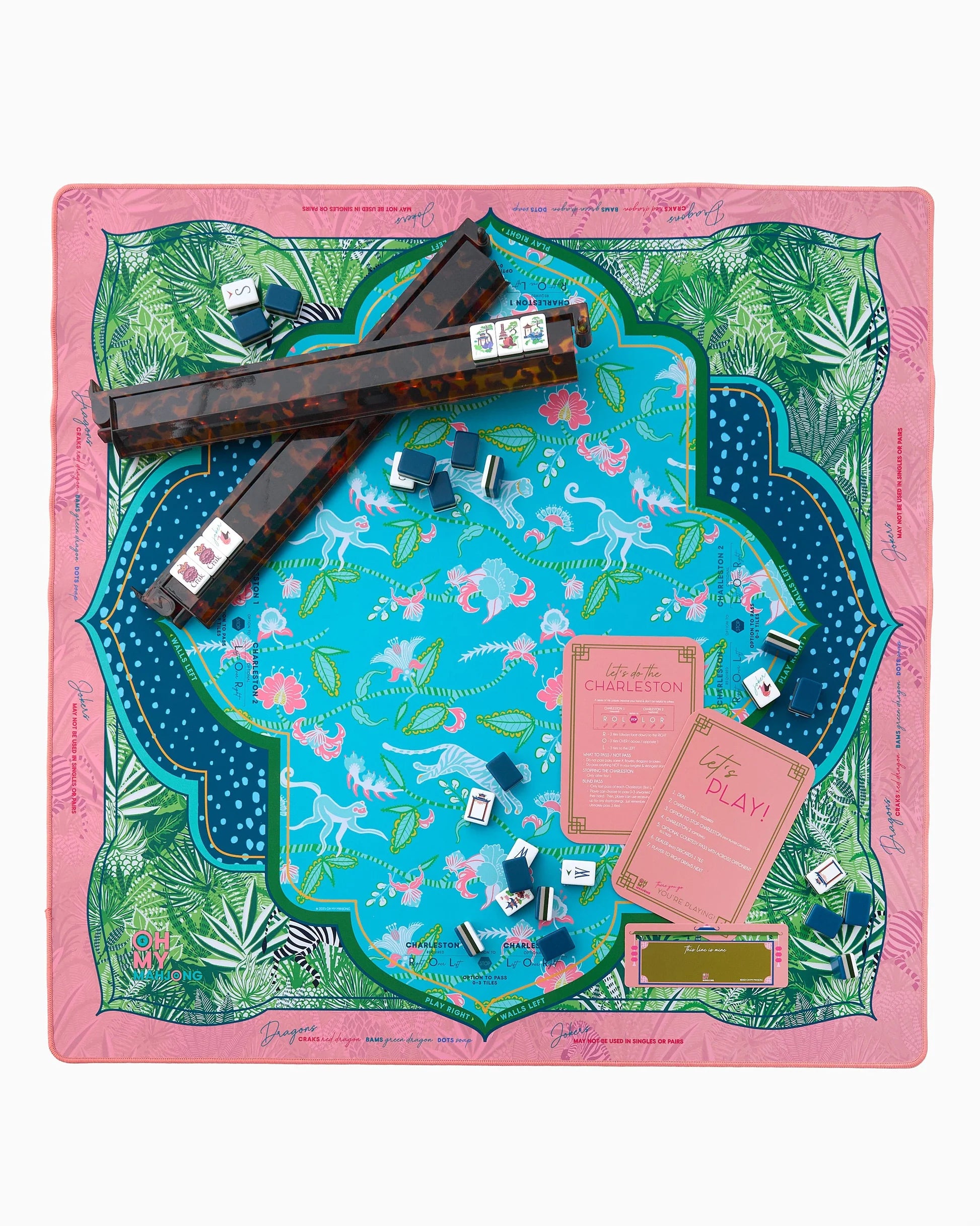 Oh My Mahjong Serengeti instructional mahjong mat with jungle green pattern with zebras and antelope and tiger floral pattern in teal with tortoise rack, coral shuffler and line finder and Gatsby mahjong tiles